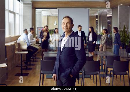 Successful adult Caucasian man manager in meeting room in front of business partners and employees Stock Photo