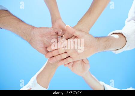 We make the best team. a mixed-aged group stacking their hands on top of each other. Stock Photo