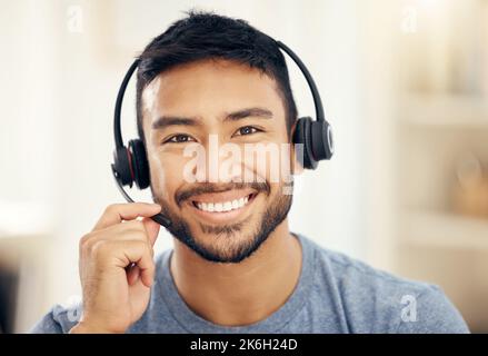 I can help you with anything you need. a young male call center agent working in an office. Stock Photo