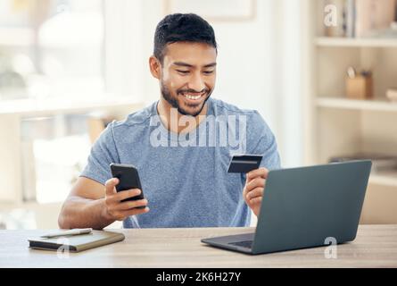 Paying bills is easy. a young businessman using a credit card and phone at work. Stock Photo