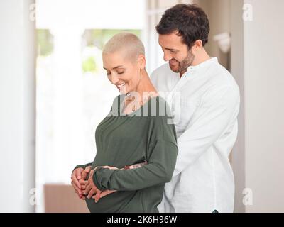 Soon well be three. an affectionate young couple standing with their hands on the expectant mothers belly. Stock Photo