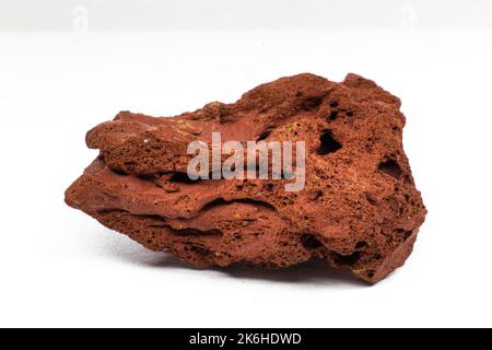 Red rough real lava stone macro focused and isolated on white surface isolated macro Stock Photo