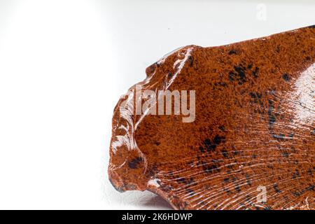 Real shiny specimen of orange Mahogany Obsidian volcanic stone macro isolated on white background Stock Photo