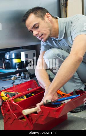 worker builder searching tools in toolbox Stock Photo