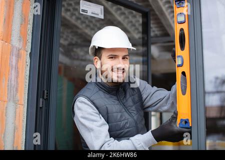 a carpenter installs a window in a low energy house Stock Photo