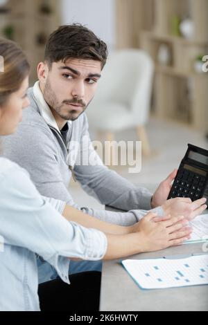 young serious couple holding reading financial documents Stock Photo