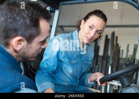 female fork lift truck driver working in factory Stock Photo