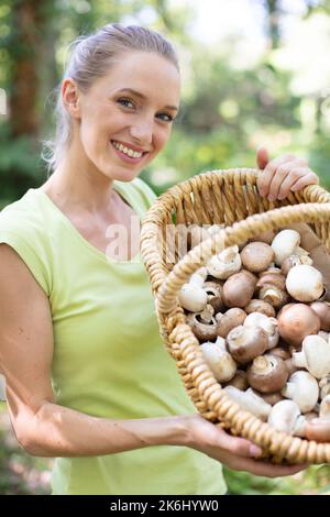 a woman mushroom picking in the forest Stock Photo