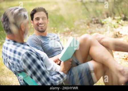 friends relaxing outside tents on camping holiday Stock Photo