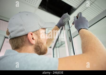 handsome young man installing bay window Stock Photo