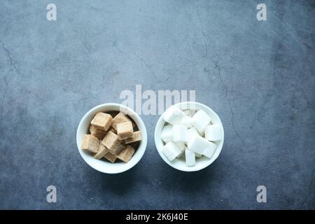 top view of brown and white sugar in a container on black  Stock Photo