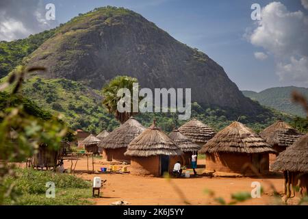 Beautiful grass thatch mud houses lay in a valley below the hills and mountains of Abim District, Uganda, East Africa. Stock Photo