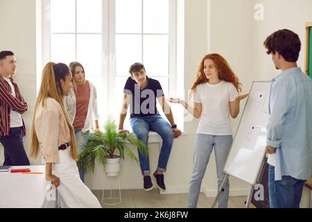 Students girl and guy making presentation using flipboard in modern classroom for classmates. Stock Photo