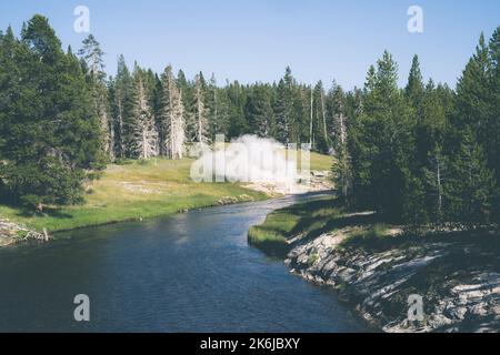 Yellowstone River, as Riverside Geyser erupts Stock Photo