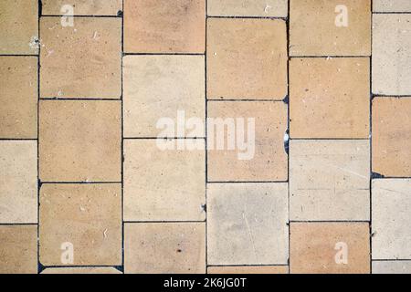 Orange brown purple old shabby worn out floor tiles with damages cracks dirt caverns potholes and paint stains. Art design background texture. Stock Photo