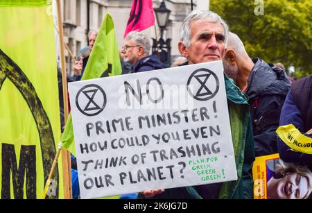 London, England, UK. 14th Oct, 2022. A protester outside Downing Street holds a sign telling Prime Minister Liz Truss to stop destroying the planet. Extinction Rebellion protesters gathered in Westminster demanding action on the climate crisis and skyrocketing energy bills. (Credit Image: © Vuk Valcic/ZUMA Press Wire) Stock Photo