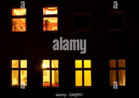 Illuminated windows. Evening in a courtyard. Vector in low poly art. Stock Vector