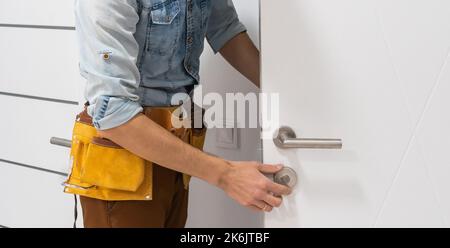 Handyman Fitting A New Door Using A Screwdriver At Home Stock Photo