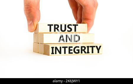 Trust and integrity symbol. Concept words Trust and integrity on wooden blocks. Businessman hand. Beautiful white background. Business, psychological Stock Photo