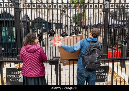 London, UK. 14 October 2022. Climate activists  from Extinction Rebellion attempt to award Liz Truss with the 'Employee of the Month' award on behalf of Shell outside Downing Street, following Liz Truss controversial stance in favour of the oil and gas industry. Credit: Andrea Domeniconi/Alamy Live News Stock Photo