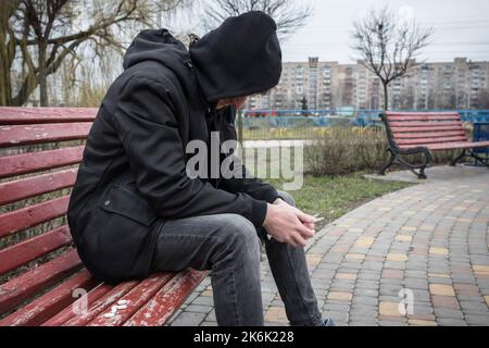Addict experiencing a drug addiction crisis, outdoors. International Day Against Drug Abuse. Stock Photo