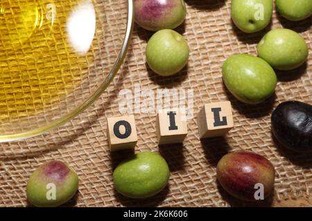 Olives and Olive Oil on wooden background Stock Photo