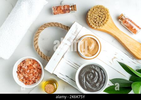 SPA cosmetics, woman body and skincare products on white background. Natural bristle dry massage brush and body or face scrub, clay mask, natural esse Stock Photo