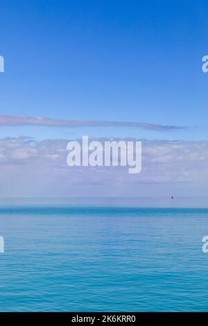the calm scene of sunrise, of a pink cotton candy clouds over the marine blue ocean Stock Photo