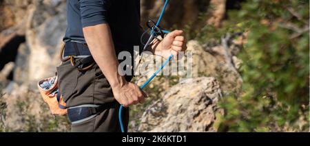 Man is engaged in extreme sports, rock climbing. Stock Photo