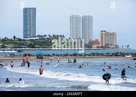 Boca Del Rio, Veracruz, Mexico - July 23, 2022: People enjoy a warm summer day at a skyline framed beach. Stock Photo