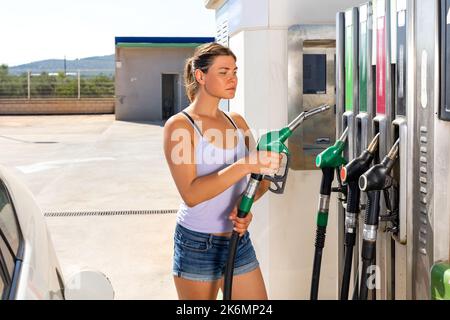 Woman refuelling her car at petrol filling station Stock Photo