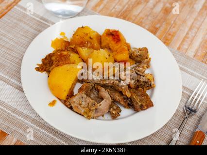 Braised rabbit served with potato garnish Stock Photo