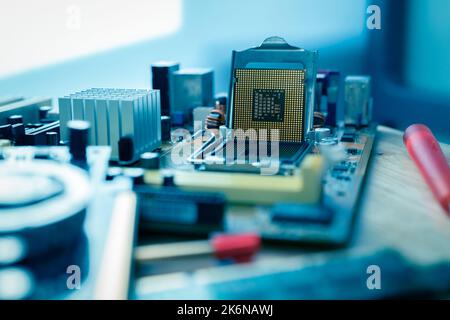 Selective focus computer chip on socket. Chipset on electronic circuit board of PC motherboard at repair workshop. CPU chip. Electronic components. Stock Photo