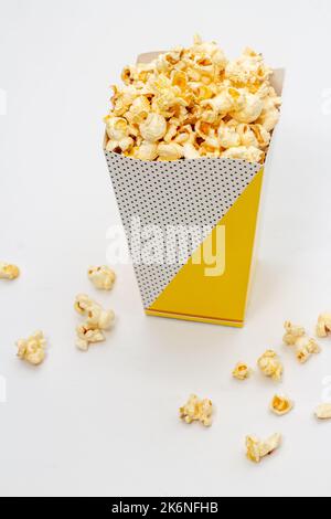 Snack of watching movie concept, Sweet popcorn in paper cup and falling on white background. Stock Photo