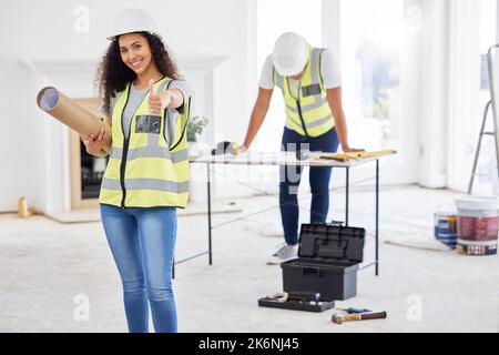 Weve got the perfect design for this room. an attractive young contractor standing inside and showing a thumbs up. Stock Photo