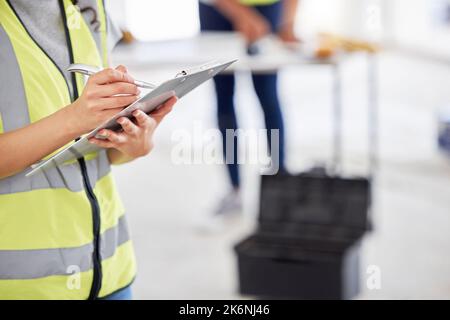 I should probably order more supplies. an unrecognisable contractor standing inside and using a clipboard. Stock Photo