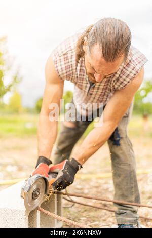 Man cutting iron using a radial saw Stock Photo