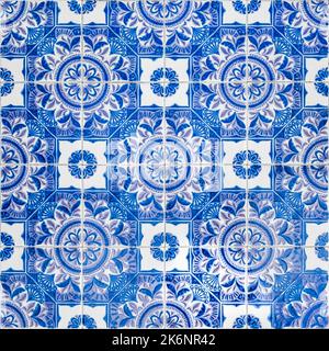 Typical texture of famous abstract blue design portuguese wall decoration tiles called Azulejo tiles with geometric floral square shaped pattern. Stock Photo
