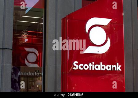 The Scotiabank logo, the third largest bank in Canada, is illuminated on a red sign out front of a bank branch in the Toronto Financial District. Stock Photo