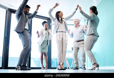Party time. Full length shot of a diverse group of corporate businesspeople dancing in their office at a work function. Stock Photo