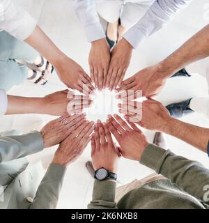 Putting her fingers to work. a group of businesspeople joining hands in solidarity. Stock Photo