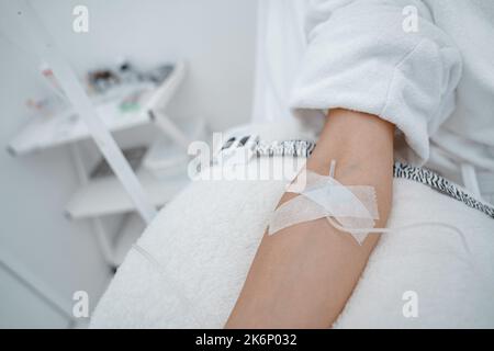Close up of woman in white bathrobe during medical procedure in beauty clinic Stock Photo