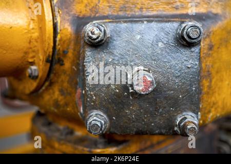 Metal hatche plate of compressor for revision close-up painted with yellow paint bolted with studs and nuts background copy space. Stock Photo