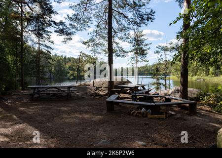 Lojukoski campfire site and wooden tables next to a lake in Repovesi National Park, Kouvola, Finland Stock Photo
