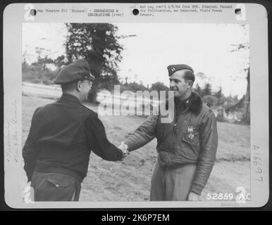 Lt. Gen. Lewis H. Brereton, Commanding General of the 9th Air force, congratulates Capt. Rush B. Shortly on receiving the Distinguished Flying Cross. Award was presented on an air strip somewhere on the Cherbourg peninsula. ',FRANCE Stock Photo