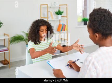 Girl is taking exam to teacher in humanities subject, actively gesticulating. Story, presentation, composition, literature. Stock Photo