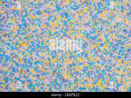 background of colorful sprinkles for sweets or beads or small balls. The concept of celebrating a birthday, party or other holidays. trendy, cute background. High quality  Stock Photo
