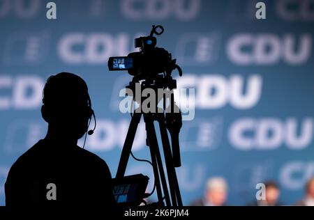 Villingen Schwenningen, Germany. 15th Oct, 2022. A cameraman is silhouetted during the state party conference of the CDU Baden-Württemberg at the exhibition center. Credit: Silas Stein/dpa/Alamy Live News Stock Photo