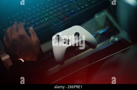Every gamers toolkit. an unrecognizable male gamer playing video games in a dark room. Stock Photo