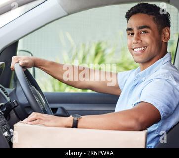 Ill be driving up to you soon. Portrait of a young delivery man driving a van. Stock Photo